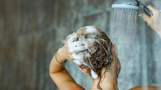 donna che si lava i capelli sovente sotto la doccia